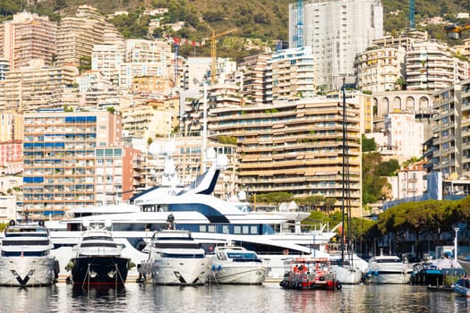 Monte Carlo, Monaco - August 2022: Port Hercule with luxury yachts,  boats, and scenery skyline