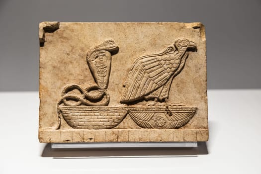 Turin, Italy - 28 December 2023: Egyptian Museum. Plaque with vulture and cobra, limestone, 400 BC