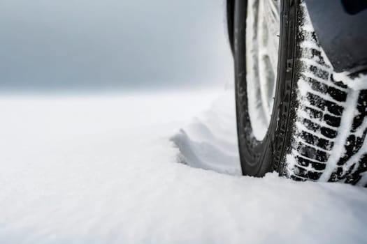 Car tires covered with snow on a snowy road. Winter driving concept. AI generated