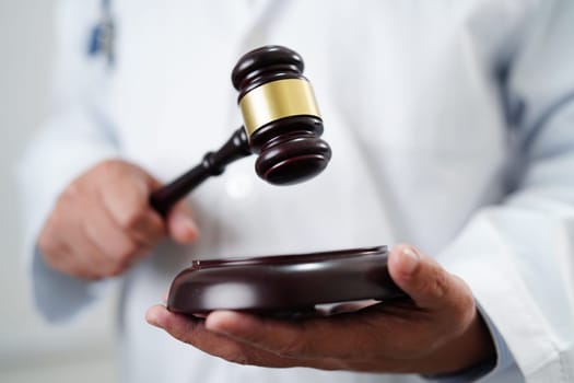 Asian doctor holding court hammer for and crime law justice, forensic medicine.