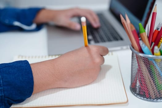 Asian teenage student write homework with laptop computer, learning university education concept.