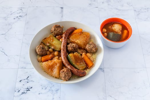 A fantastic traditional oriental and hot couscous in a plate with harissa sauce