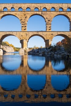 The Pont du Gard over Gardon river. Ancient Roman three-tiered aqueduct bridge. Vertcal photography taken in Vers-Pont-du-Gard, Provence, southern France