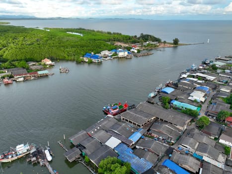 Aerial landscape of Pak Nam Prasae estuary in Rayong, Thailand. Fishing community, mangrove forest, and river showcase sustainable ecotourism and net-zero travel in a biodiverse coastal ecosystem.