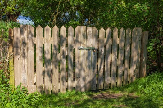 Brown wooden garden fence with garden gate, Germany