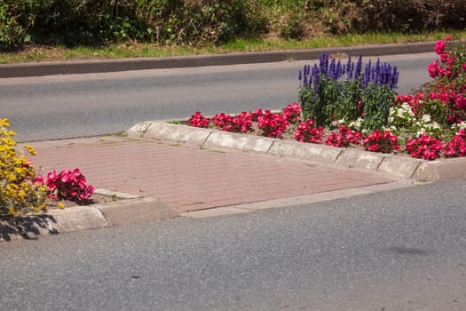 Traffic island on road with crosswalk and flower bed, Germany