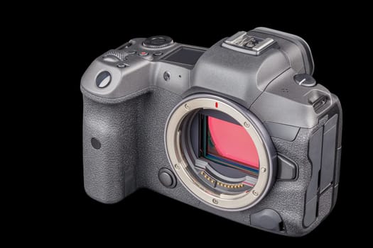 black 2020s professional 35mm full-frame mirrorless camera body with flip screen isolated on black background.