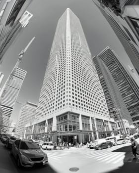 Imposing high-rise building viewed from below, surrounded by urban architecture.