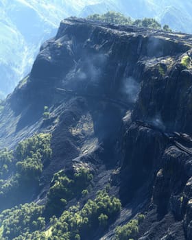 Dramatic rocky cliff face with lush vegetation and misty mountain ranges.