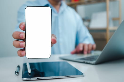 Businessman hand holding  holding smartphone with white empty screen in hand, Smartphone mockup for online shopping, Booking and banking concept, Online education or online business with copy space.