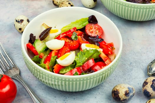 Salad of peppers, tomatoes, cucumbers, green lettuce and quail eggs. Quail eggs salad.