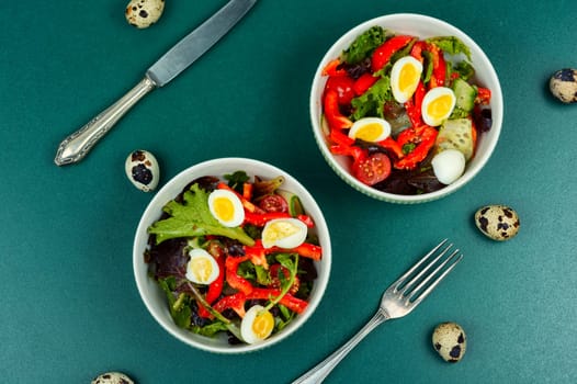 Salad of peppers, tomatoes, cucumbers, green lettuce and quail eggs. Quail eggs salad.