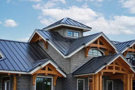 Close-up house retro roof panel with standing seam and fasteners. Classic style black metal panel with rebate joint. Modern galvanized steel roofing sheet with ribs. Falz roofing. Building's covering