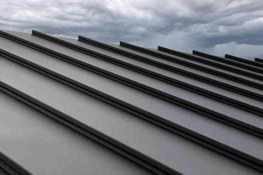 Close-up house retro roof panel with standing seam and fasteners. Classic style black metal panel with rebate joint. Modern galvanized steel roofing sheet with ribs. Falz roofing. Building's covering