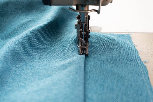 Industrial sewing machine with blue fabric, working place, manufacture for clothes, handmade, small local business, textile industry