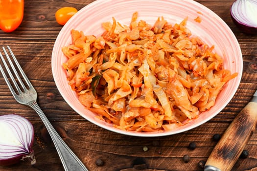 Appetizing stewed cabbage on a plate. German cuisine. Rustic style.