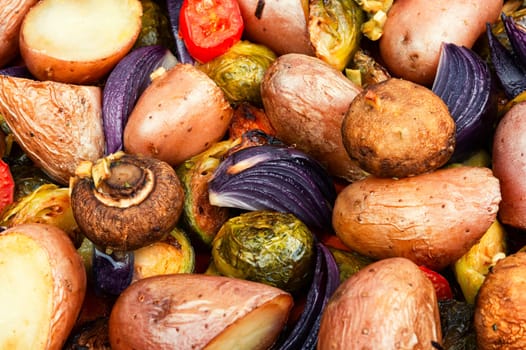 Roasted baked mushrooms, Brussels sprouts, and potatoes, garnished with onion in the oven dish. Free space for your text.