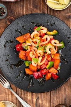 Fried crispy shrimp with fruit sauce. Salad with shrimps, prawns and caramel sauce.