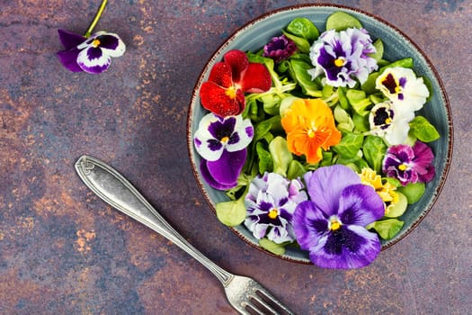 Healthy salad with green and edible flowers. Vitamin salad of flowers.