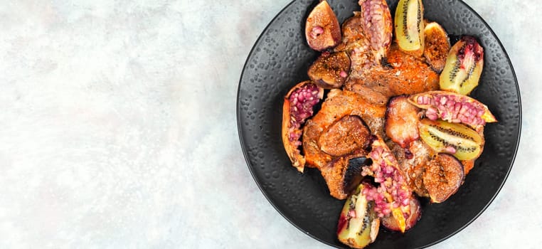 Meat pork steaks roasted with figs, kiwi and pomegranate. Free space for your text.