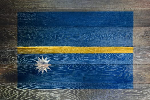 A Nauru flag on rustic old wood surface background blue yellow stripe white star
