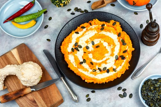 A colorful pumpkin risotto with pumpkin puree and parmesan cheese.