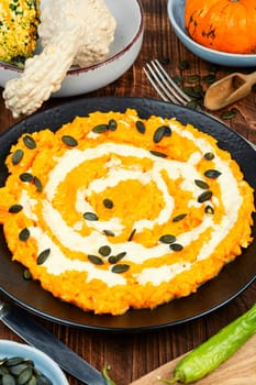 A colorful pumpkin risotto with pumpkin puree and parmesan cheese.
