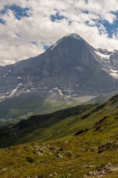 The majestic north face of the Eiger (3967m - 13015ft) under a cloudy sky in summer. Seen from Mannlichen. Bernese Alps, Switzerland