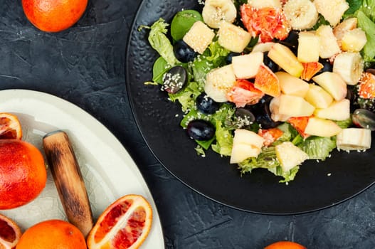 Fruit salad of red orange, apple, banana and lettuce. Healthy eating.