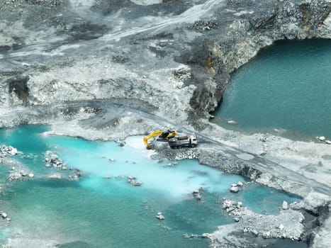 Open pit mine industry. Limestone quarry with backhoe and truck in operation. Heavy machinery in mining industry and construction material supply. Landscape of resource extraction in a industrial site