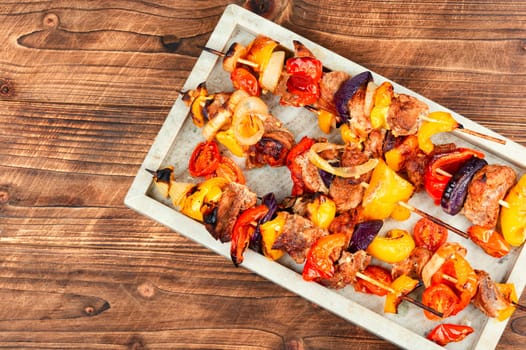 Meat kebabs with vegetables, shish kebab BBQ meat with onions. Top view with copy space.