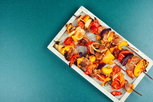 Meat kebabs with vegetables, shish kebab BBQ meat with onions. Top view with copy space.