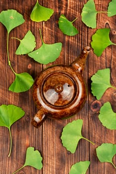 A cup of herbal tea, green Ginkgo biloba leaves. Herbal tea in a cup on a wooden table