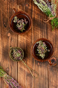 Herbal tea with fresh heather, homeopathy. Heather blossom tea on wooden table.