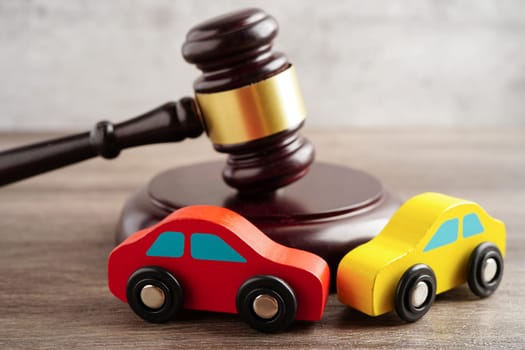 Car accident lawsuit and insurance, Judge hammer with car model.