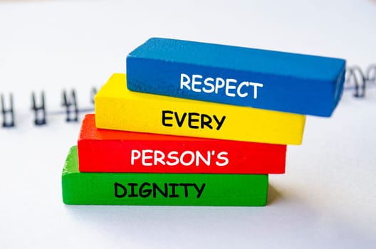 Respect every person's dignity text on multicolored wooden blocks. No to negativity concept.