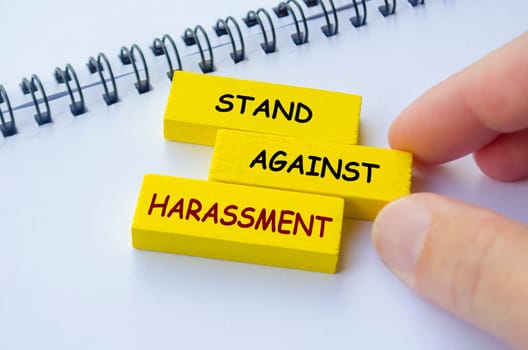 Stand Against Harassment text on yellow wooden blocks. No to Harassment concept.