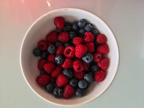 Close-up tasty ripe fresh summer berries - raspberry and blueberry.