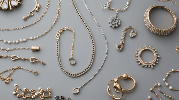 Assortment of elegant gold and diamond jewelry including necklaces, bracelets, rings, and earrings on gray background, showcasing fine accessories.