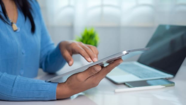 Businesswoman use devices manage finances, Analyze diagrams statistics in office, Close up back view of female accountant work on electronic gadgets prepare financial report on tablet and laptop.