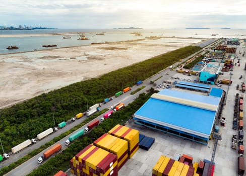 Trucks lined up at a warehouse loading dock, preparing for container delivery. Logistics, supply chain, and freight transportation industry. Vital role in global commerce, from sea to land routes.