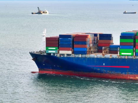 Aerial view of container cargo ship at sea. International shipping and logistics. Maritime freight transportation. Global trade and export import industry. Commercial vessel carrying containers.
