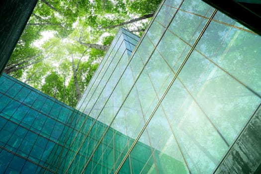 Eco-friendly building in modern city. Sustainable glass office building with trees for reducing CO2. Green architecture. Building with green environment. Sustainability corporate. Net zero emissions.