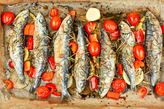 Oven baked italian fish sardoncini or sardines, with tomatoes, lemon and rosemary.