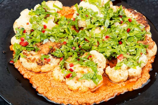 Delicious roasted cauliflower with fresh parsley and sauce.