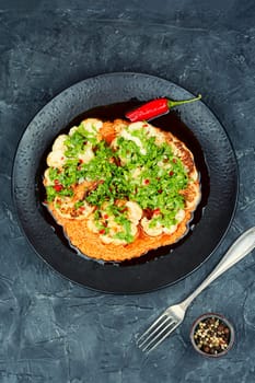 Delicious roasted cauliflower with fresh parsley and sauce.