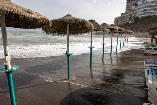 Foamy sea waves on the sandy beach of Bajondillo in Torremolinos, Malaga, Costa del Sol, Spain