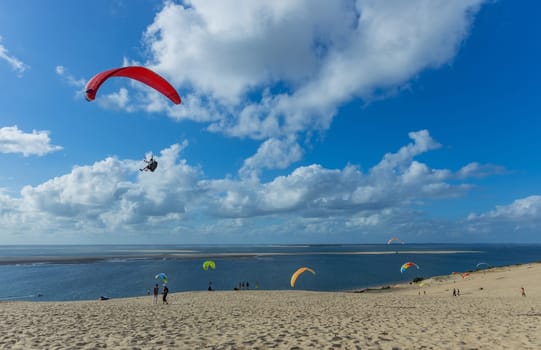 Dune of Pilat, France - August 14, 2024: People paragliding at the Great Dune of Pilat, Arcachon Basin, Nouvelle Aquitaine, France.