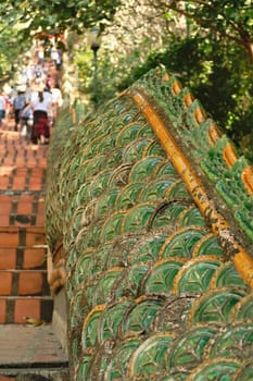 Many visitors on the Naga Stairway up to the Wat Phra That Doi Suthep Temple, stairs lined with two giant Phaya Nagas, Thai Dragons, Snakes, Serpent, close to Chiang Mai, Thailand 2023