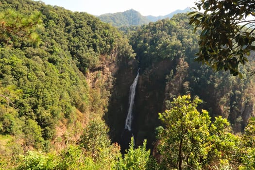 Spectacular view onto the Nam Tok Mae Surin Waterfall, surrounded by a lush, dense forest, jungle, vegetation, close to Khun Yuam, Thailand 2023